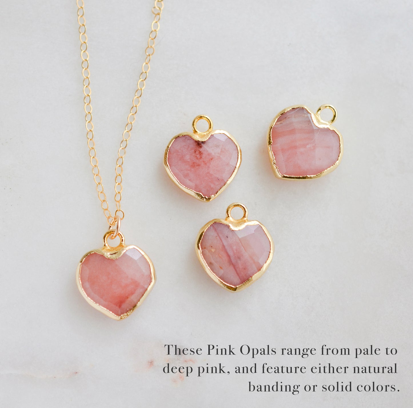 Showing the multiple colors that natural pink opal comes in.
Handmade necklace with a natural pink opal heart-shaped pendant on a 14k gold filled chain. Handcrafted dainty gemstone jewelry by Gemnia.