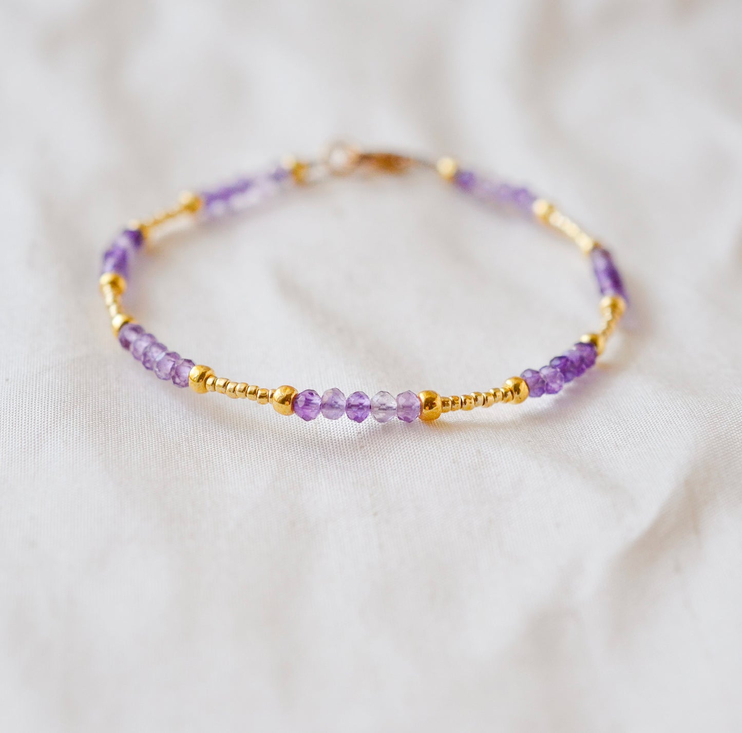 Handmade beaded gemstone crystal bracelet in gold filled or sterling silver. These bracelets feature a gemstone of your choice on a bracelet that can be stacked with others or worn alone. Shown in purple amethyst.
