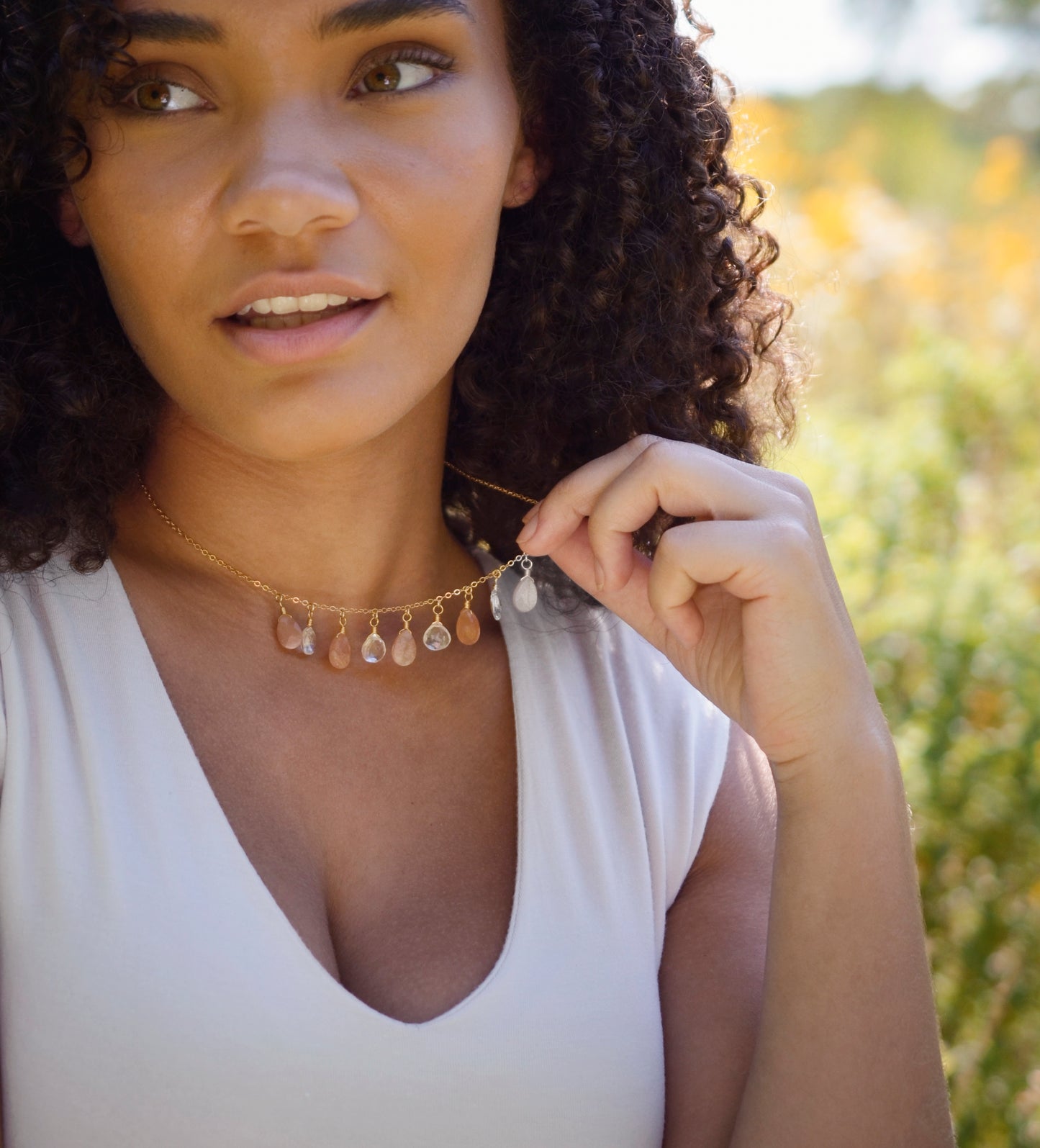 Orange, peach Sunstone and clear Crystal Quartz teardrops dangle off a 14k gold filled chain. Modeled image.