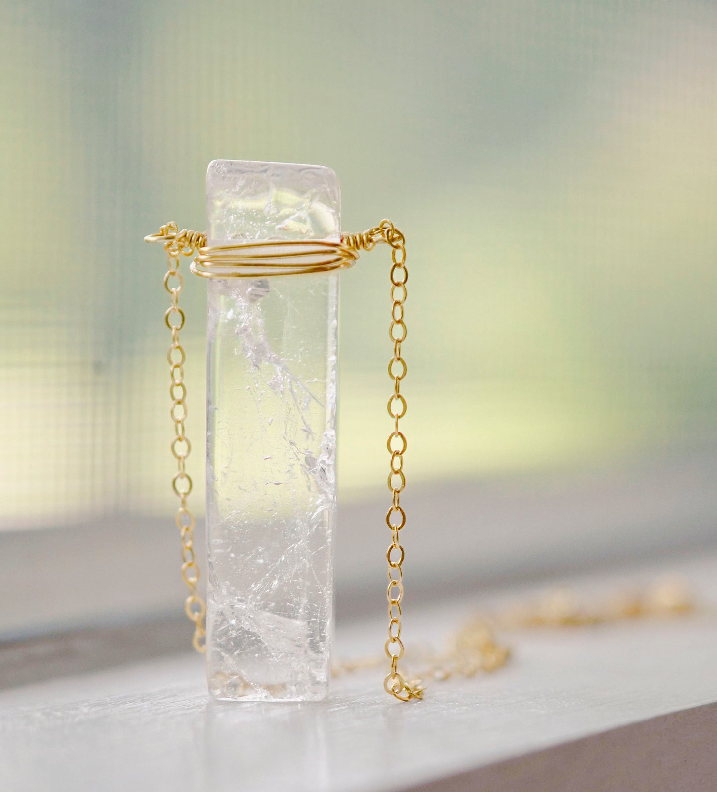 Rectangular shaped natural clear crystal Quartz gemstone set into a 14k gold filled chain.