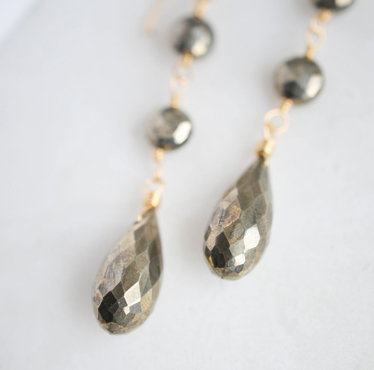 Handcrafted long pyrite crystal earrings. Close up of faceted teardrops.