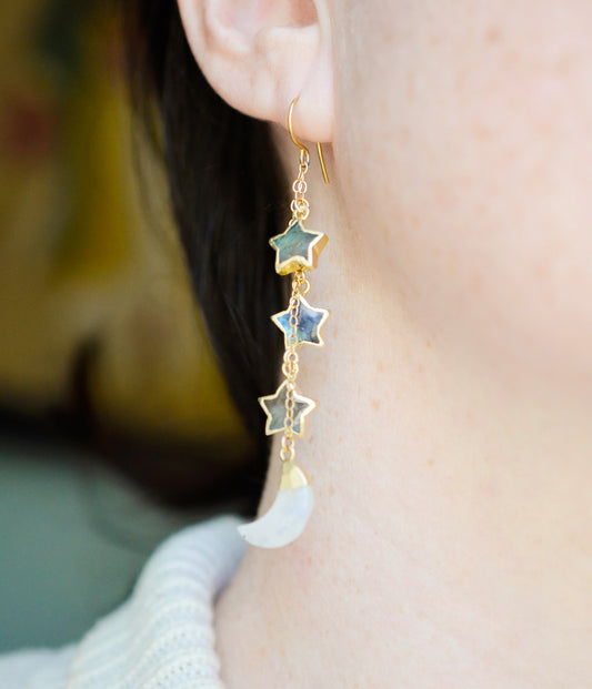These earrings are handmade with natural labradorite gemstone stars and rainbow moonstone crescent moons. Shown in gold, these dangles are long, but light weight. Modeled image.