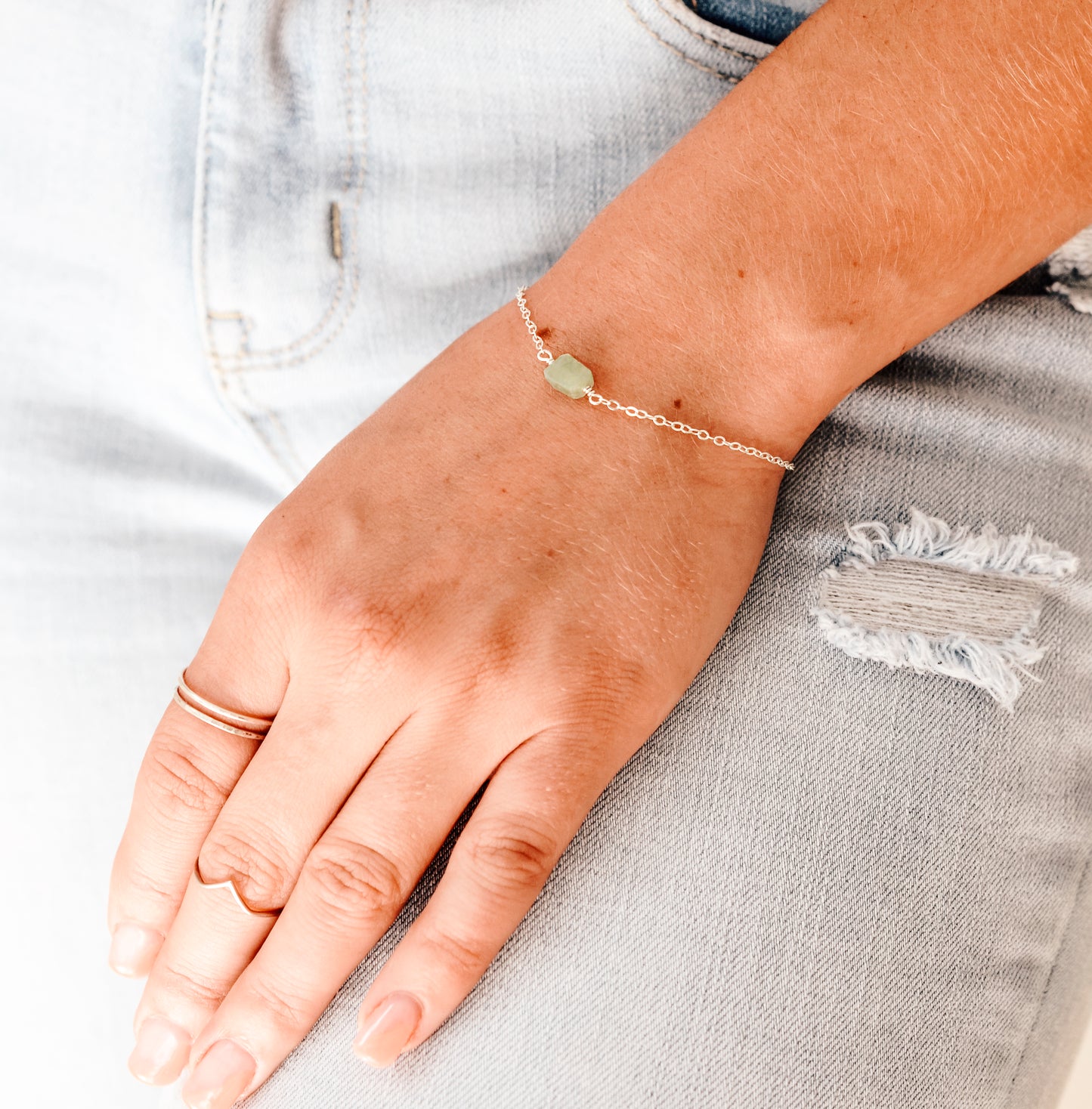 Pale green raw jade stone set onto a 14k gold filled chain. Modeled image.