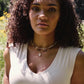 Creamy white natural Cowrie shell set onto a 14k gold filled chain. Modeled image.