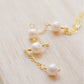 Close up image of the pearls. Four semi-round white freshwater pearls are suspended in a Y-style necklace on a 14k gold filled chain. Each pearl is approximately one inch apart. This necklace is also available in sterling silver.