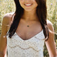 A woman is wearing a dainty, natural black druzy quartz pendant set on a 14k gold filled chain. 