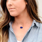 Natural blue lapis lazuli slice set onto a sterling silver chain. The stone is smooth polished with raw edges and oval in shape. Natural pyrite and calcite flecks are visible within each stone.  Modeled image.