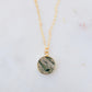 A genuine, natural moss agate circle necklace set on a 14k gold filled chain. This boho, dainty, smooth polished pendant is handmade in Connecticut by Gemnia Jewelry.