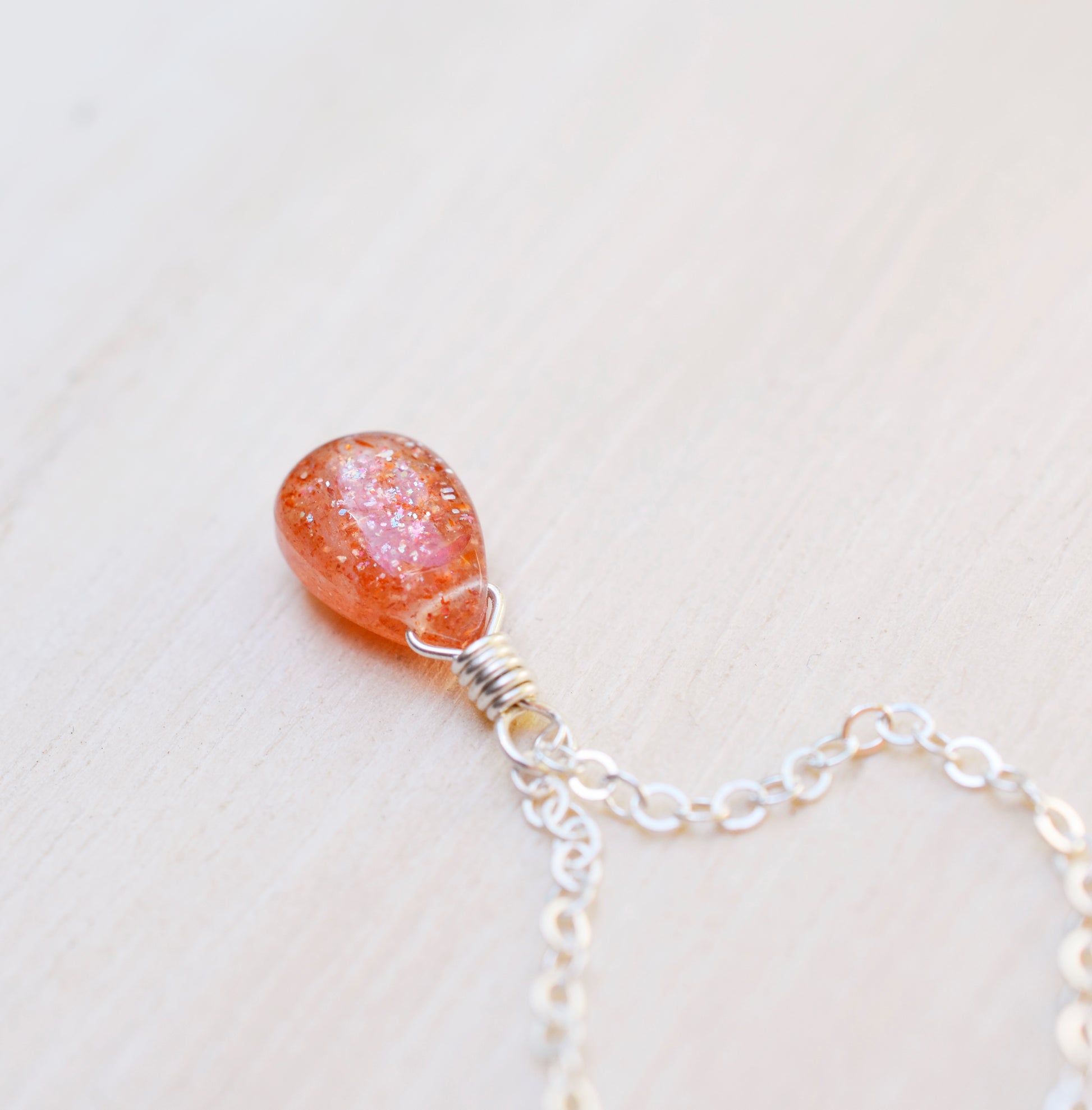 Orange Sunstone smooth polished teardrop pendant on a sterling silver chain.