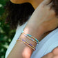 Handmade beaded gemstone crystal bracelet in gold filled or sterling silver. These bracelets feature a gemstone of your choice on a bracelet that can be stacked with others or worn alone. Modeled image.