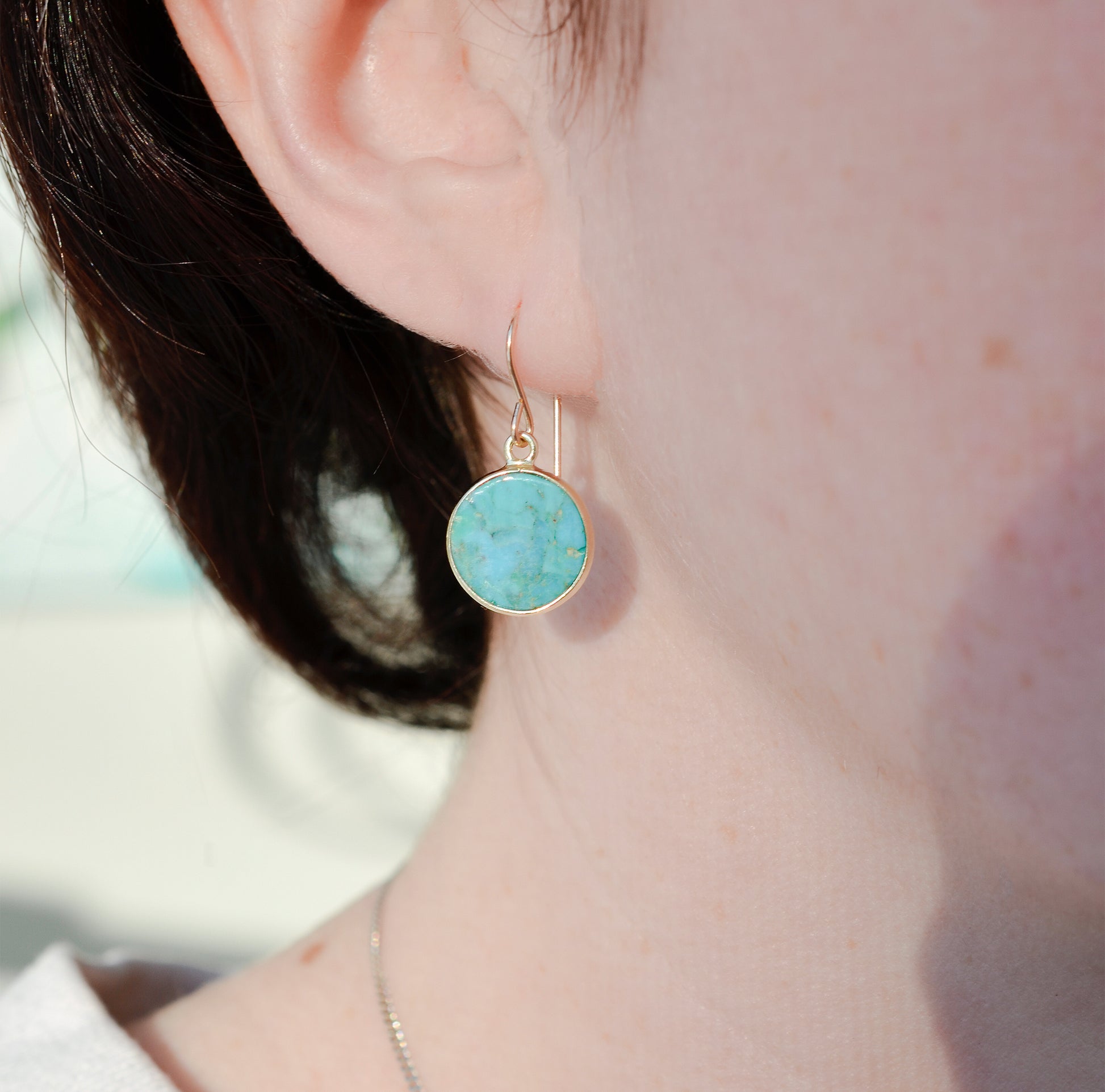 Modeled image of a woman wearing natural round coin shaped blue turquoise earring dangles in 14k gold filled.