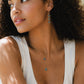 A woman wearing celestial Labradorite jewelry handmade with faceted stars and moons.This pieces are available as a set and are made in Connecticut by Gemnia.
