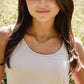Woman wearing a beaded labradorite necklace with a star pendant in a natural setting.
