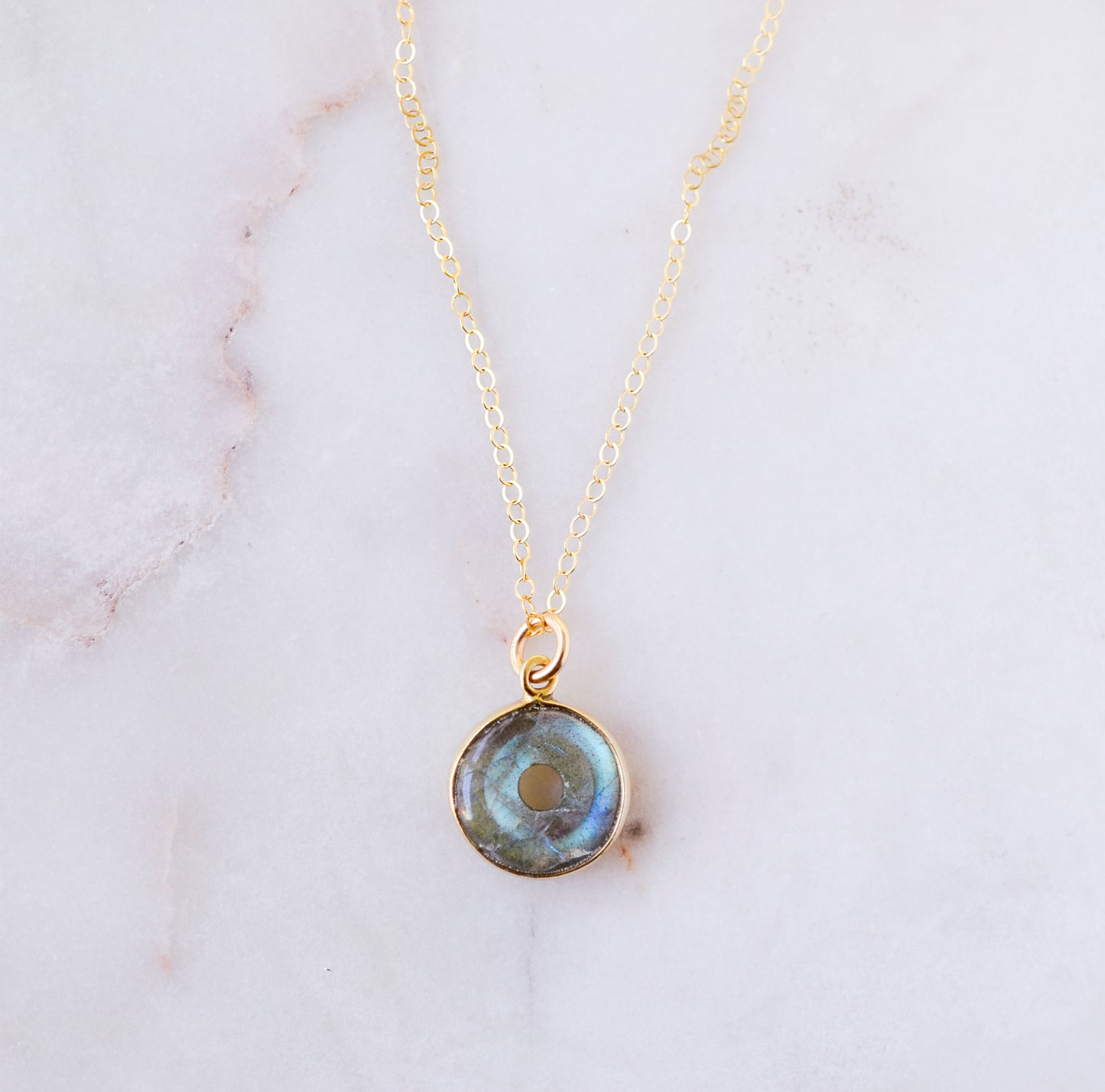 Round natural blue labradorite donut shaped pendant set on a 14k gold filled chain. This necklace is handmade by Gemnia Jewelry in Connecticut.