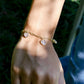 Gold bracelet with heart-shaped charms modeled on a wrist.