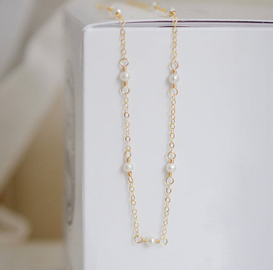 Natural white freshwater pearls within a dainty 14k gold filled chain. Each pearl is approximately 3mm in size and are spaced 2 inches apart.
