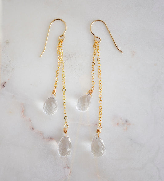 Long clear crystal quartz earrings with two teardrop dangles hanging from a dainty 14k gold filled chain.