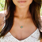 A modeled image of a woman wearing a gold Labradorite necklace. The handmade pendant pendant is bezeled in gold and set on a 14k gold filled chain. This necklace is also available in sterling silver. The stone is oval in shape and flashes blue, green, or yellow.