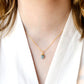 Modeled image of a woman wearing a dainty gold aquamarine pendant necklace. Handcrafted in Connecticut by GEMNIA.