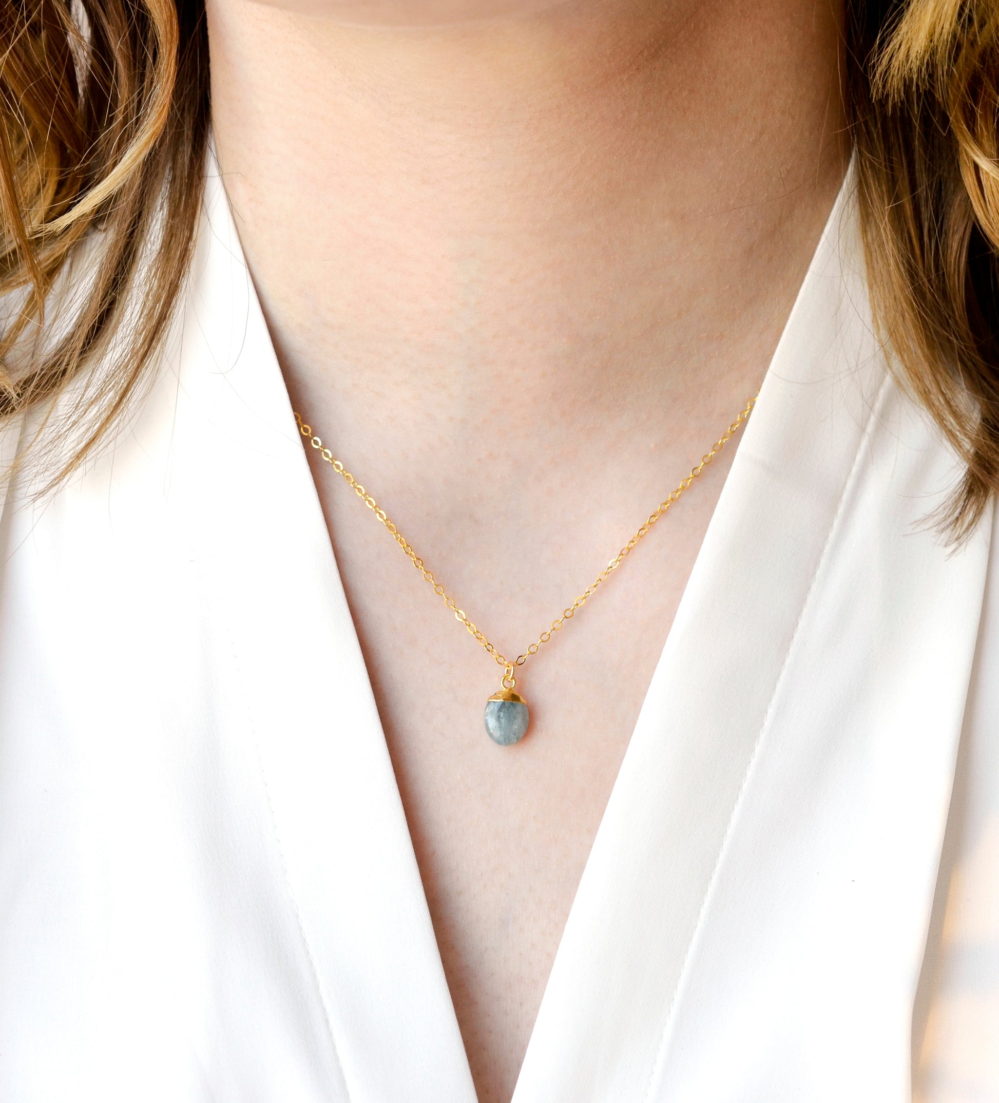 Modeled image of a woman wearing a dainty gold aquamarine pendant necklace. Handcrafted in Connecticut by GEMNIA.