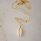 Single cowrie shell suspended from a 14k gold filled chain necklace.