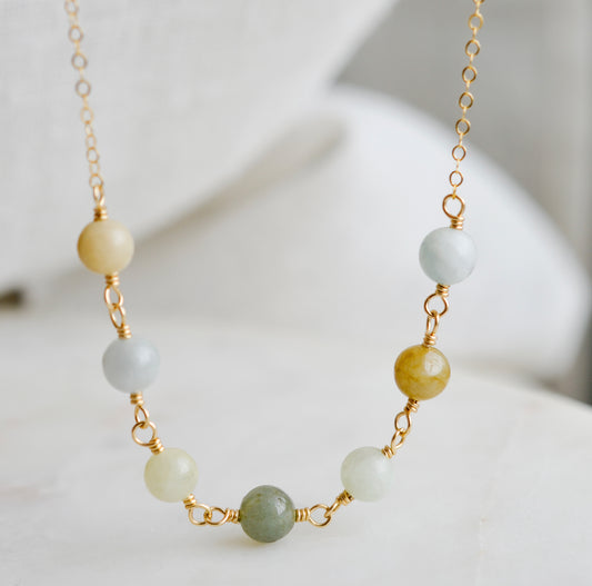 A multi-color burma jade necklace featuring seven round green, brown, yellow, or blue natural stones. Handmade in Connecticut by Gemnia Jewelry.