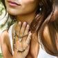 Close-up of a woman wearing layered labradorite and pearl necklaces with a star in the center.