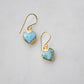 Aqua blue, natural Larimar stone heart earrings in gold. The stones range in blue, white, or green with the occasion mark of brown or black.