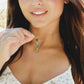 A modeled image of a woman wearing a labradorite necklace with three faceted gemstones bezeled in gold then suspended from a 14k gold filled dainty chain. Handmade in Connecticut.