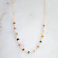 Close up of multi-color Tourmaline chain necklace. Each crystal is a different color. Shown in gold.