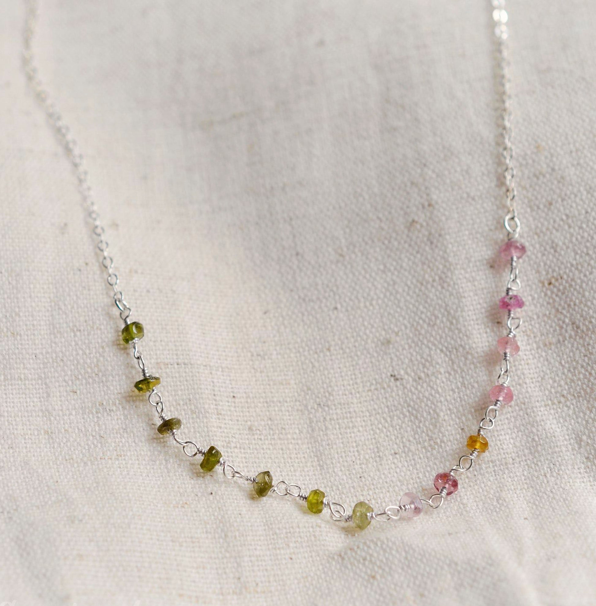 Close up of multi-color Tourmaline chain necklace. Each stone is a different color. Shown in sterling silver.