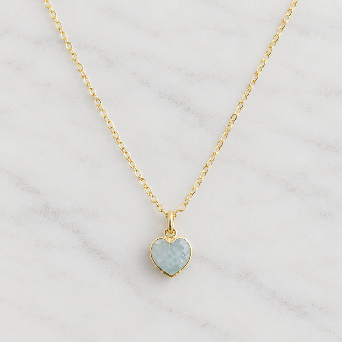 A natural pale blue aquamarine stone heart pendant set on a delicate 14k gold filled chain. This necklace is handmade by Gemnia. Dainty Minimalist Gemstone Jewelry.