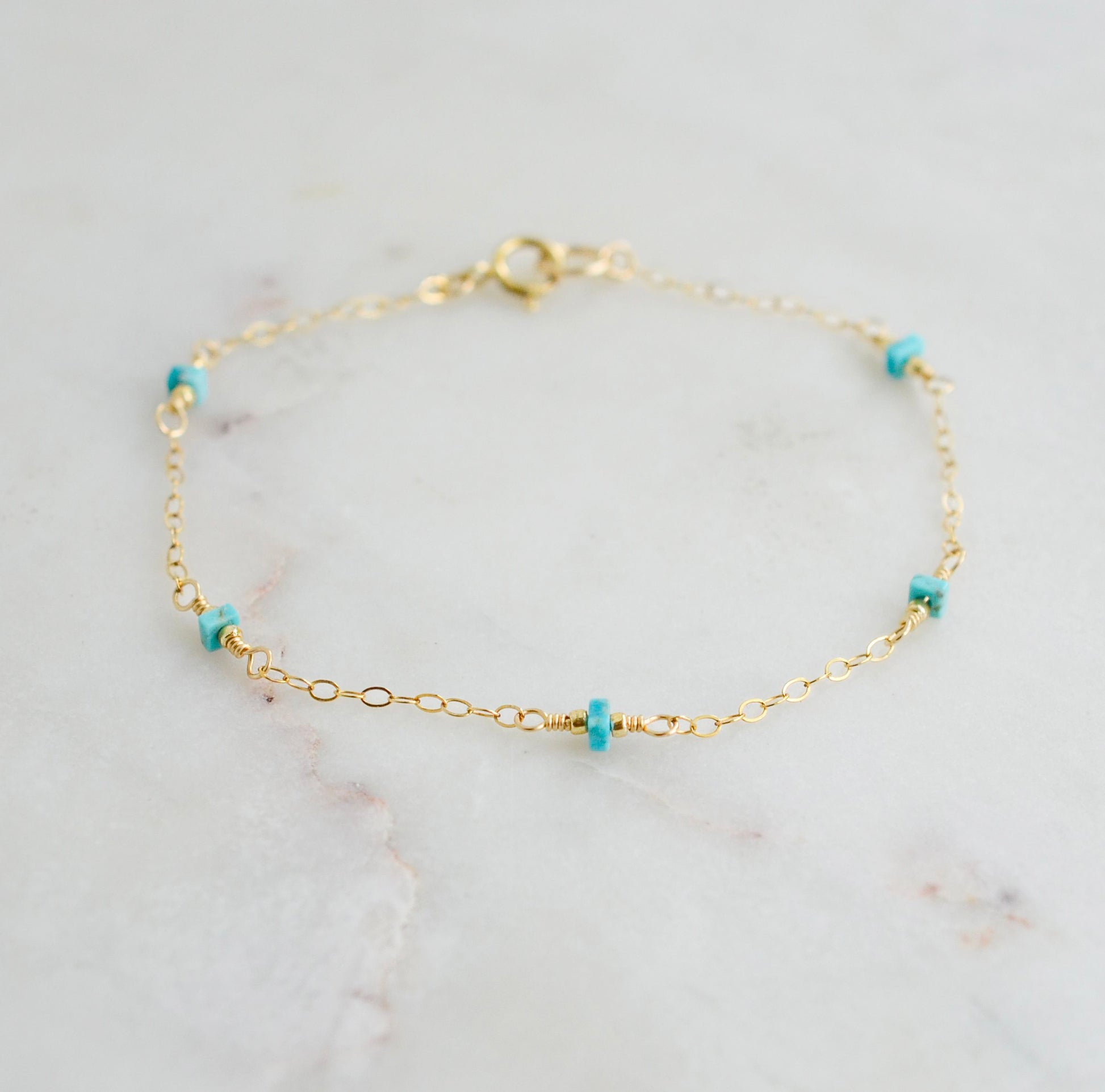 A turquoise and gold filled bracelet with a chain-link design, featuring a gold filled band and turquoise stones. Handmade in Connecticut by Gemnia Jewelry.
