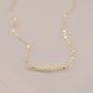 White freshwater pearl bar necklace shown in 14k gold filled. The peals are small and slightly irregular in shape.