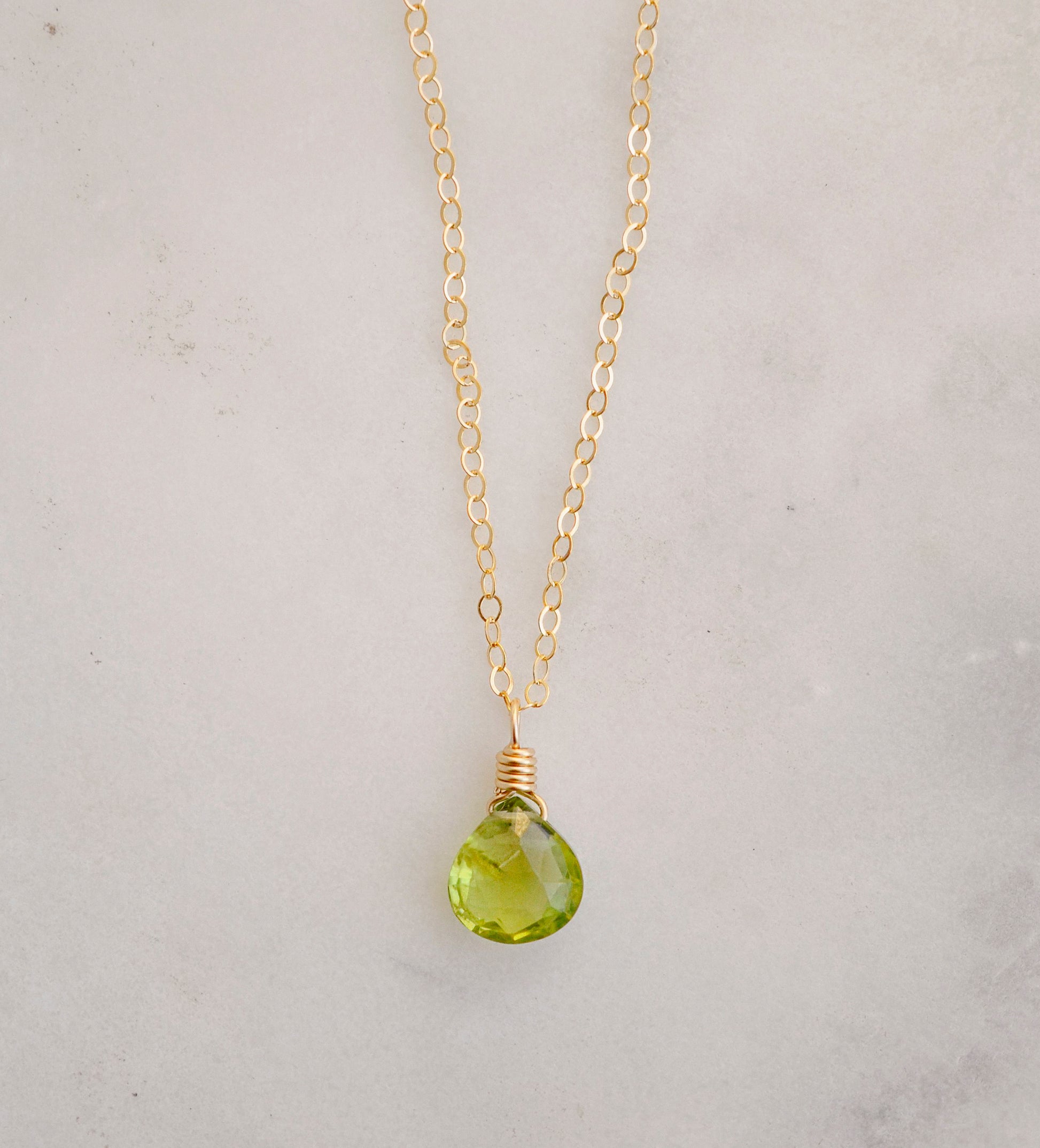 Natural green Peridot faceted teardrop suspended from a 14k gold filled cable chain.
