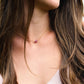 Small, dainty raw pink Tourmaline crystal set on a 14k gold filled chain. Modeled image.