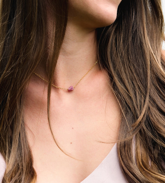 Small, dainty raw pink Tourmaline crystal set on a 14k gold filled chain. Modeled image.