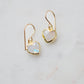 Natural rainbow moonstone stone heart earrings in gold. The stones are white, but flash blue with movement.