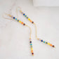 Two long, straight bars of crystals arranged in a rainbow pattern separated by a dainty chain. The gold style is shown. 