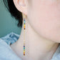 Modeled image. Two long, straight bars of crystals arranged in a rainbow pattern separated by a dainty chain. The gold style is shown. 