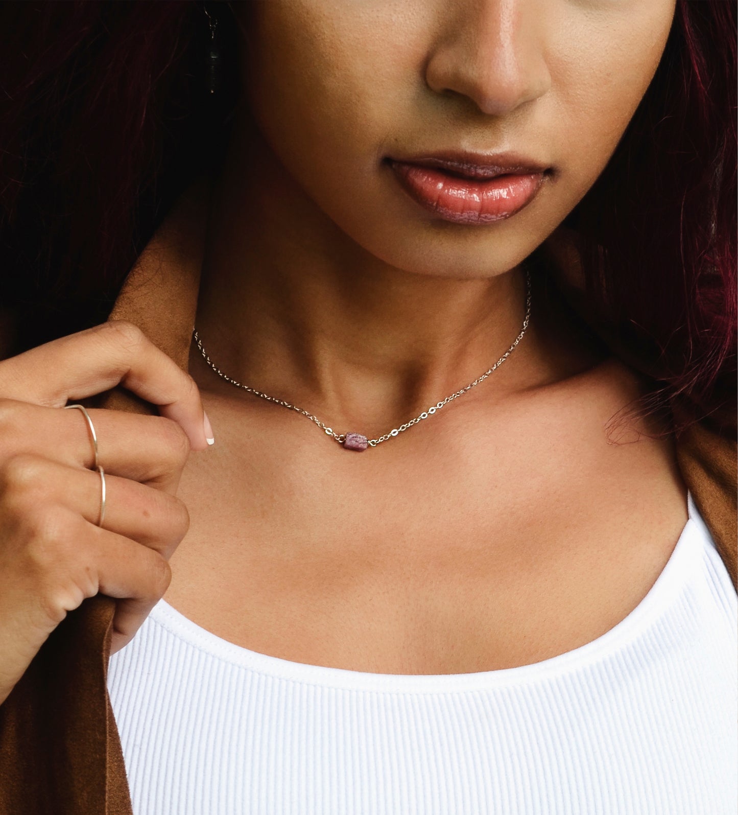 Small, dainty raw pink Tourmaline crystal set on a sterling silver chain. Modeled image.