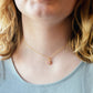Pale pink Rhodochrosite smooth polished slice set in gold. Shown on a gold chain. Modeled image.