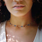 Tiny stones arranged in the order of the seven chakras or rainbow colors. Colors include: purple, blue, aqua, green, yellow, orange, and red. Modeled image.