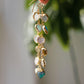 These handmade earrings feature blue and white natural stone hearts bezeled in gold. Each gemstone is a different color and includes: labradorite, larimar, mother of pearl, aquamarine, and rainbow moonstone. Long and light weight they make the perfect romantic gift. They are 3 inches long.