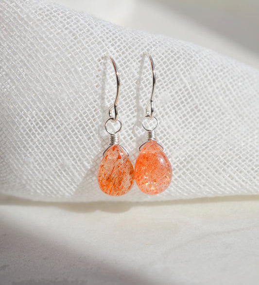 Handmade natural sunstone teardrop dangle earrings in sterling silver. These dainty, genuine stone earrings are made by Gemnia in Connecticut. 