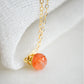 Natural orange Sunstone necklace. The stone is a faceted round and set onto a 14k gold filled chain.