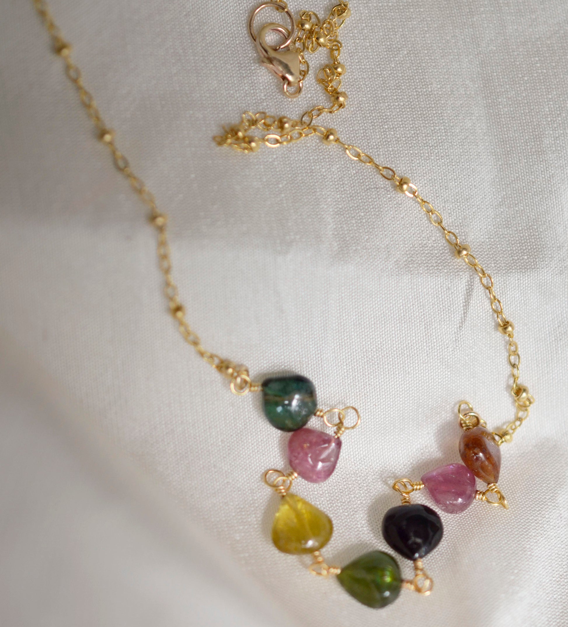 Multi color Tourmaline drops chain necklace. Shown in gold. Stone colors include: pink, green, black, yellow, or brown.
