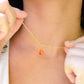 Natural orange triangular shaped Carnelian gemstone set onto a gold chain. Modeled image. 