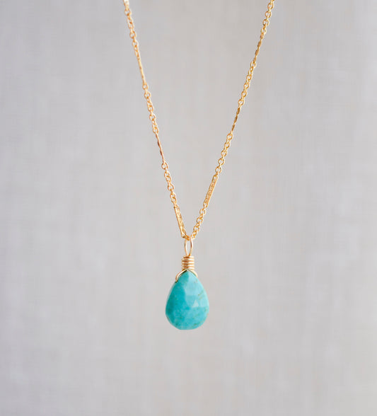 Bright natural Arizona Turquoise teardrop suspended from a 14k gold filled chain. Close up image. 