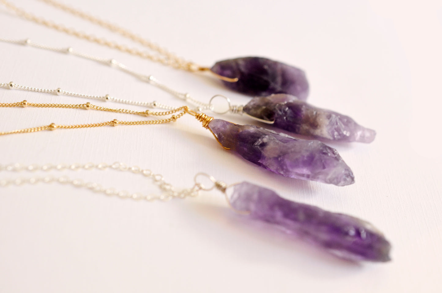 Raw purple amethyst crystals set onto chains. 